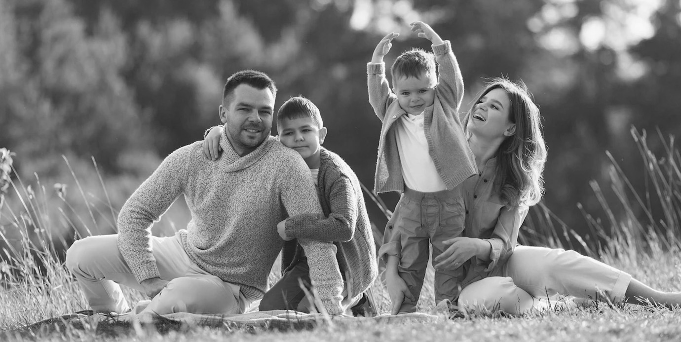 Family of four sitting on field